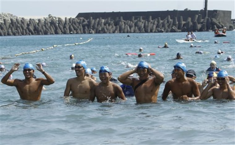Japanese athletes swim ashore into the Suao harbor, northeastern Taiwan, Monday, Sept. 19, 2011. Six Japanese swimmers completed a two-day, 150-kilometer swim from Japan’s Yonaguni Island to Taiwan to thank the island for its disaster aid after the March 11 earthquake and tsunami. (AP Photo/Wally Santana)